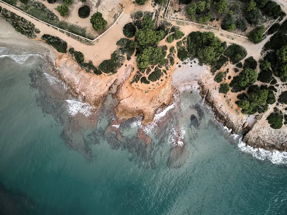 Cala de La Renegà, entre pinos y roca, con el agua turquesa